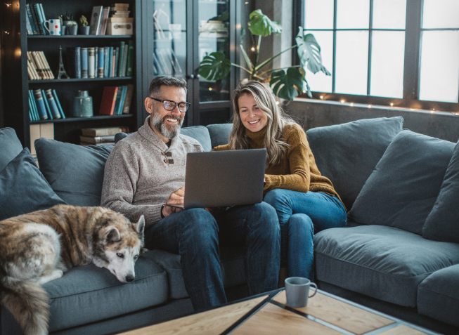 Couple smiling on couch with dog
